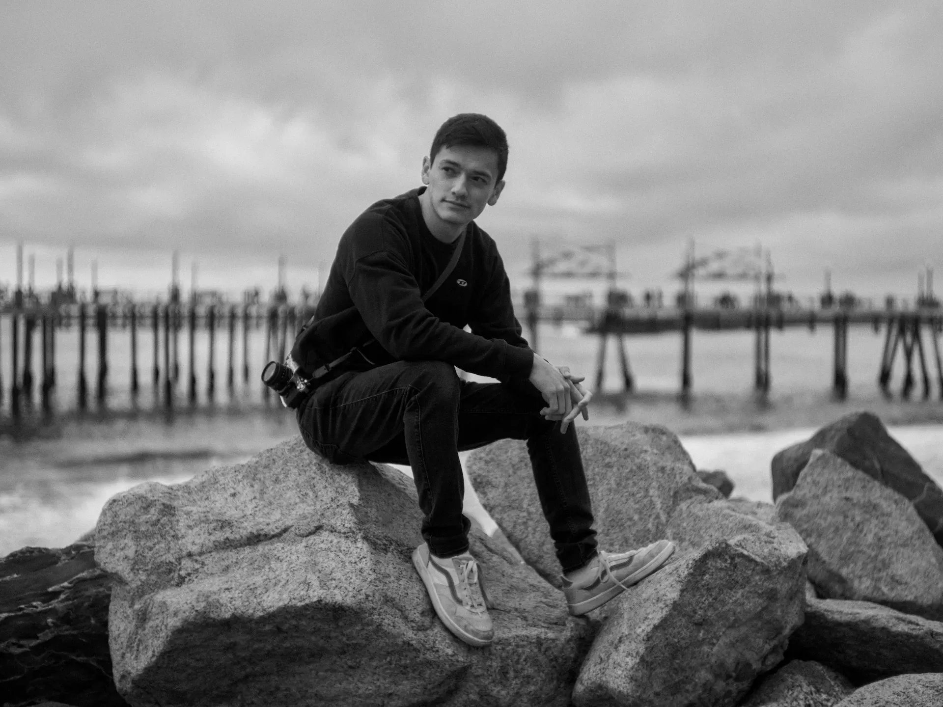 Jackson Hayes, sitting on a rock by the beach.